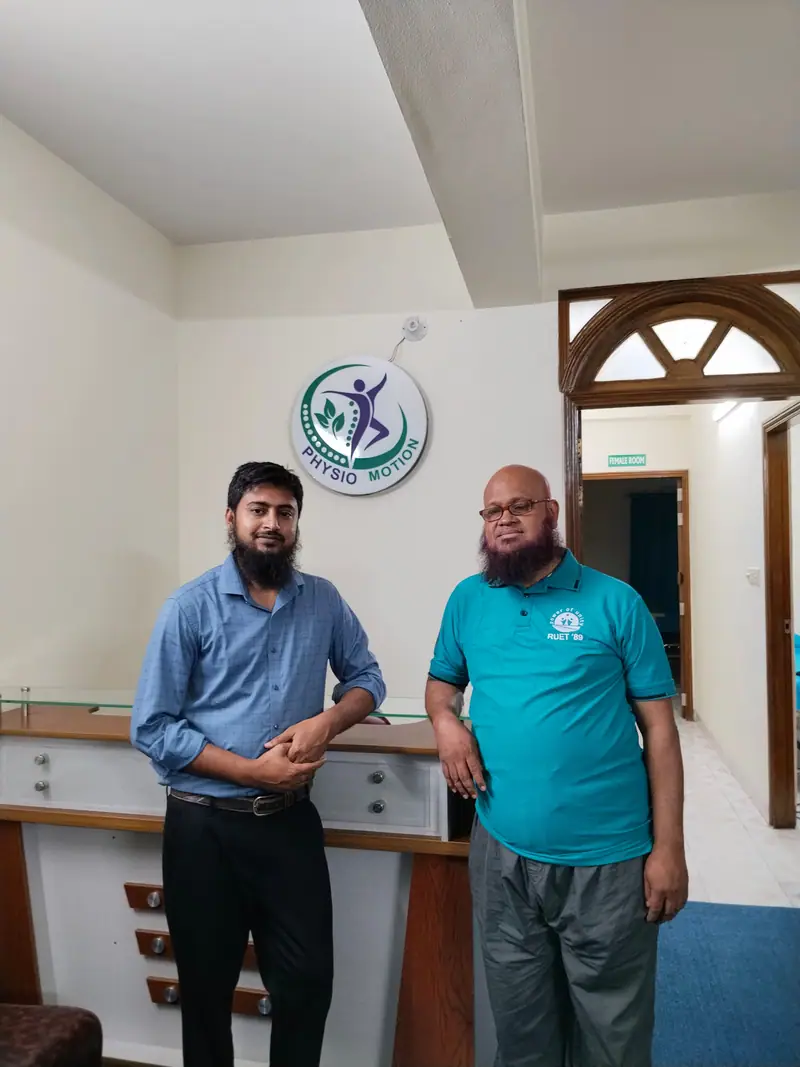 The reception area at Physio Motion in Uttara, with the clinic logo on the wall and a signposted separate treatment room