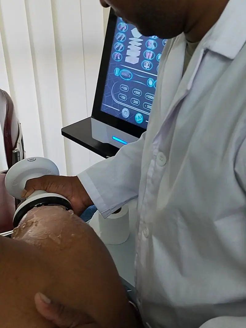 A clinician delivering focused shockwave therapy to a patient’s shoulder at Physio Motion